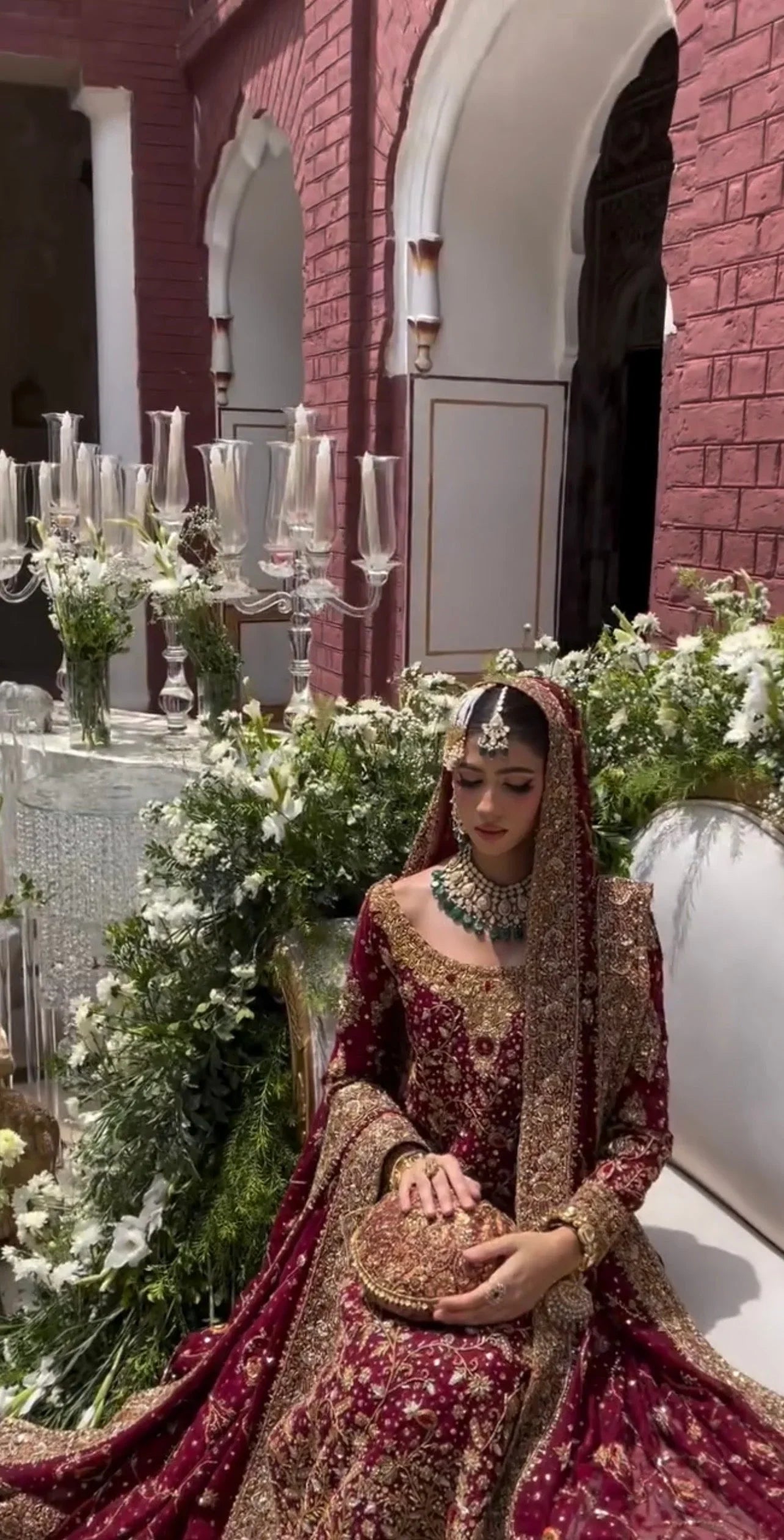 Haris Shakeel Ishq Series bridal ensemble in deep romantic maroon featuring intricate adda work and hand embellishment with fine dabka and handworked motifs spread generously across the shirt, sleeves, and flowing lehenga with richly embellished borders, paired with a heavily worked dupatta with ornate edging, perfect for brides seeking classic sophistication and traditional grandeur.