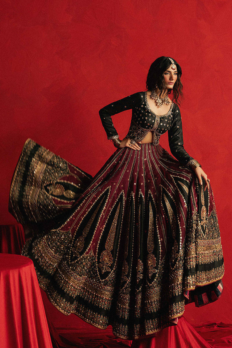 Mohsin Naveed Ranjha Dil Raas black Indian silk lehenga choli featuring a full-sleeved choli with metallic and silk thread embroidery in star-like patterns, paired with a lehenga in deep maroon fading to black with embroidered cypress trees, palmette motifs, mirrorwork, sequins, and golden thread detailing, finished with maroon and gold layered borders, complete with a lightweight organza dupatta featuring maroon and gold floral sprays, gota pati, and adda work, perfect for bridal wear and formal celebratio
