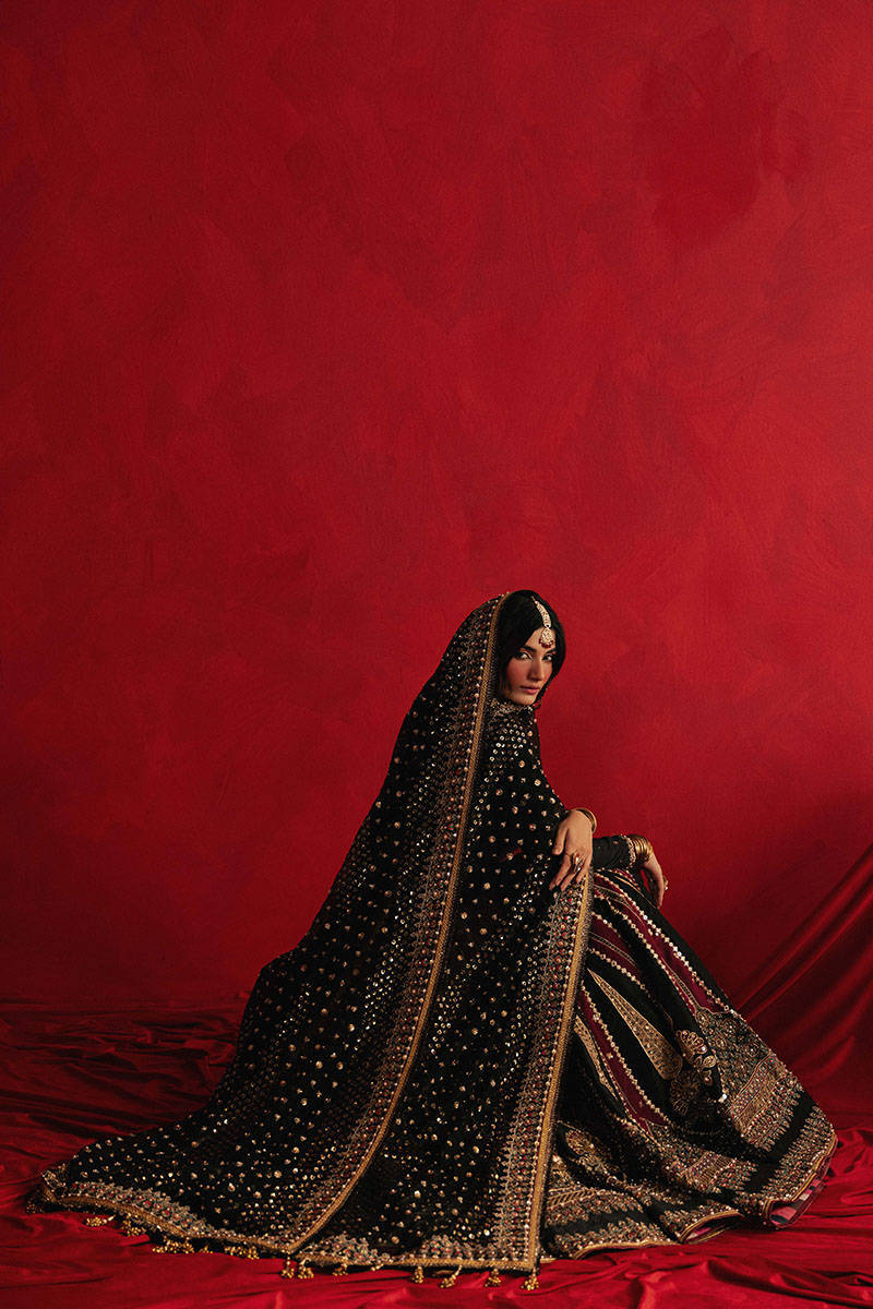 Mohsin Naveed Ranjha Dil Raas black Indian silk lehenga choli featuring a full-sleeved choli with metallic and silk thread embroidery in star-like patterns, paired with a lehenga in deep maroon fading to black with embroidered cypress trees, palmette motifs, mirrorwork, sequins, and golden thread detailing, finished with maroon and gold layered borders, complete with a lightweight organza dupatta featuring maroon and gold floral sprays, gota pati, and adda work, perfect for bridal wear and formal celebratio