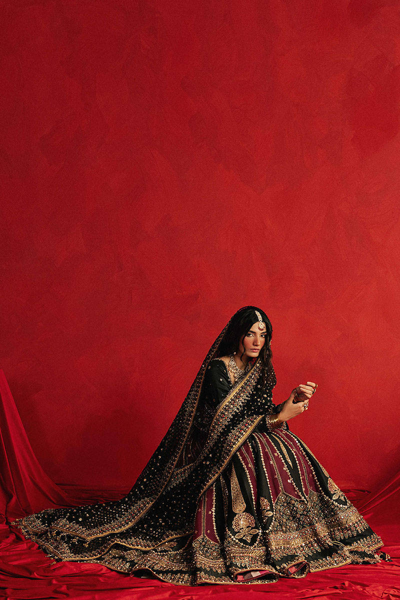 Mohsin Naveed Ranjha Dil Raas black Indian silk lehenga choli featuring a full-sleeved choli with metallic and silk thread embroidery in star-like patterns, paired with a lehenga in deep maroon fading to black with embroidered cypress trees, palmette motifs, mirrorwork, sequins, and golden thread detailing, finished with maroon and gold layered borders, complete with a lightweight organza dupatta featuring maroon and gold floral sprays, gota pati, and adda work, perfect for bridal wear and formal celebratio