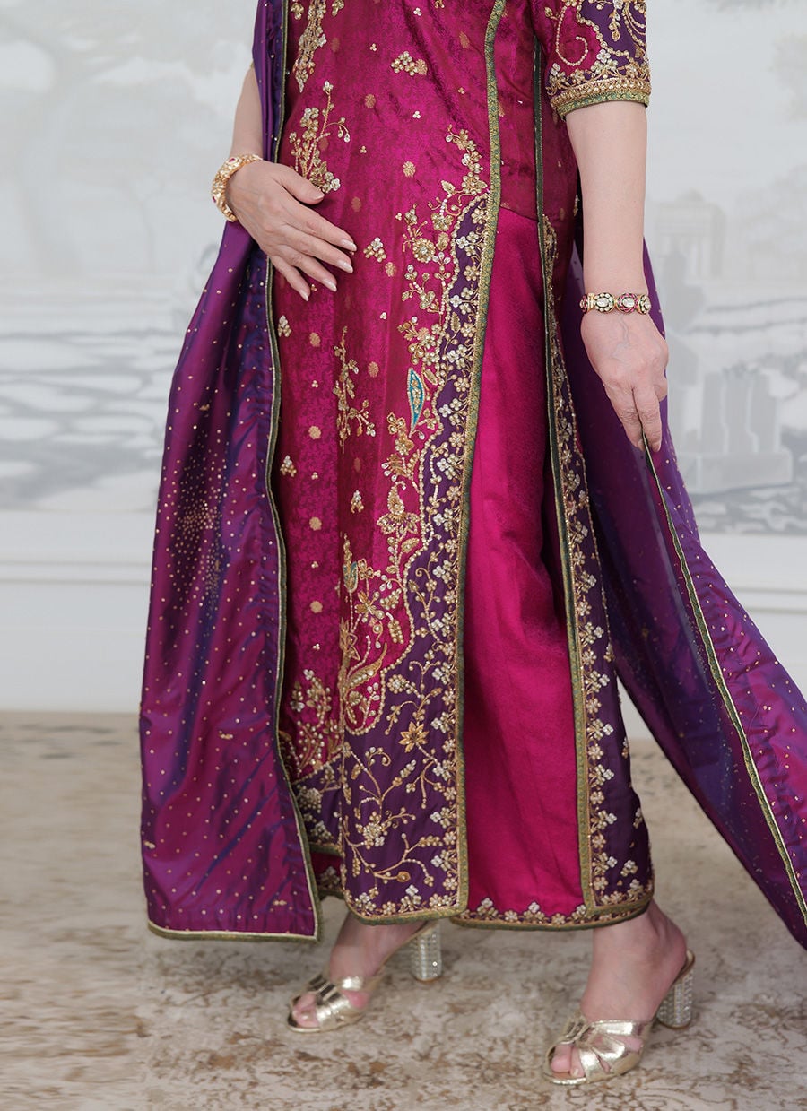 Farah Talib Aziz Bita magenta pure silk kurta featuring intricate hand embellishments with resham, zari, and sequins on the neckline, sleeves, daaman, and borders, paired with a luxurious purple tissue chaadar richly worked with golden embellishments and subtle shimmer accents, perfect for festive gatherings and formal occasions.