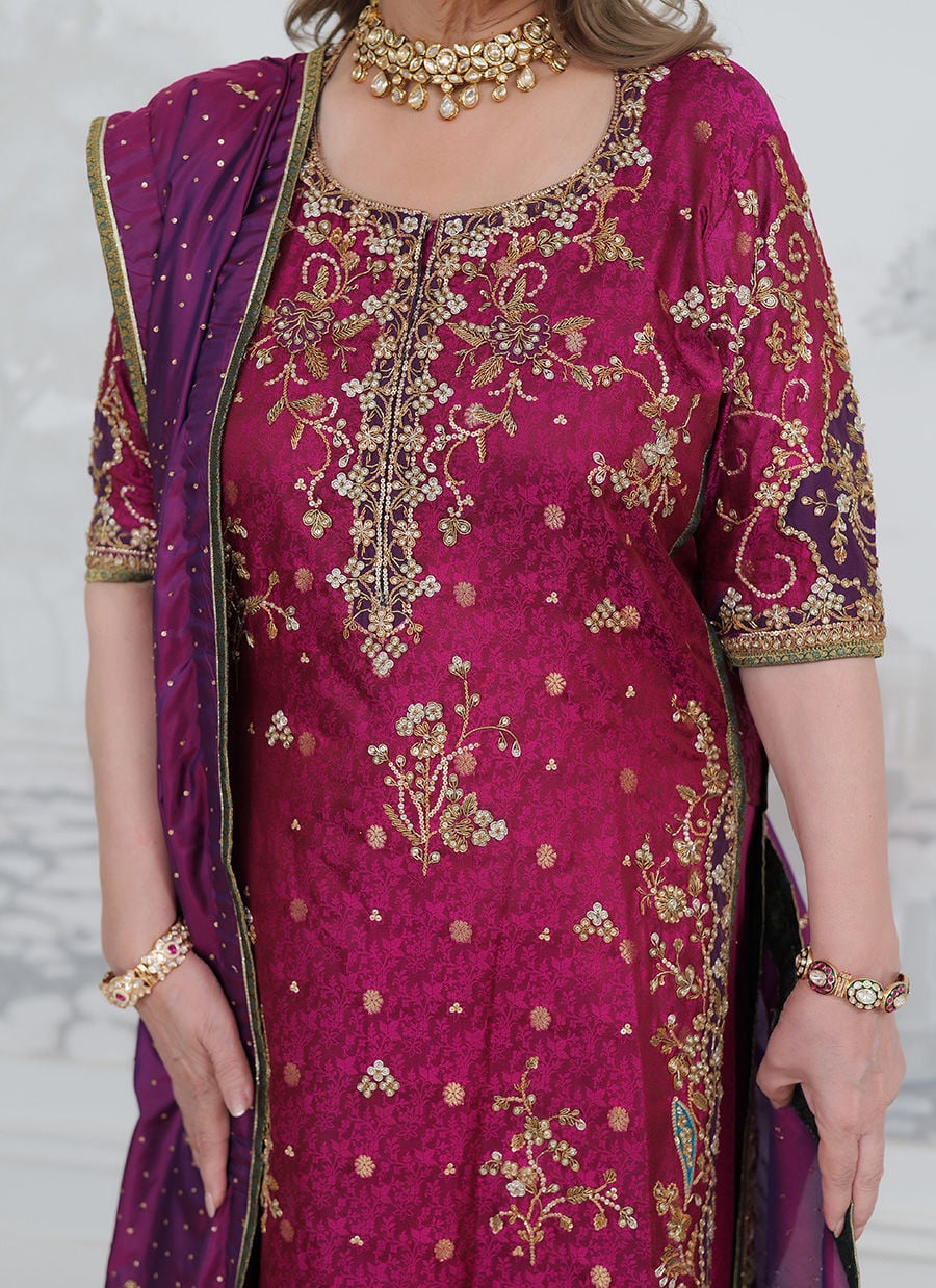 Farah Talib Aziz Bita magenta pure silk kurta featuring intricate hand embellishments with resham, zari, and sequins on the neckline, sleeves, daaman, and borders, paired with a luxurious purple tissue chaadar richly worked with golden embellishments and subtle shimmer accents, perfect for festive gatherings and formal occasions.