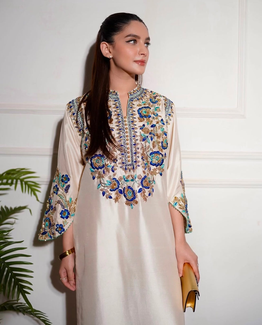 Aleena Khan Aleenah white ensemble featuring a delicately embroidered shirt with intricate motifs, paired with beautifully tailored trousers and a gracefully flowing dupatta, perfect for formal occasions and festive celebrations.