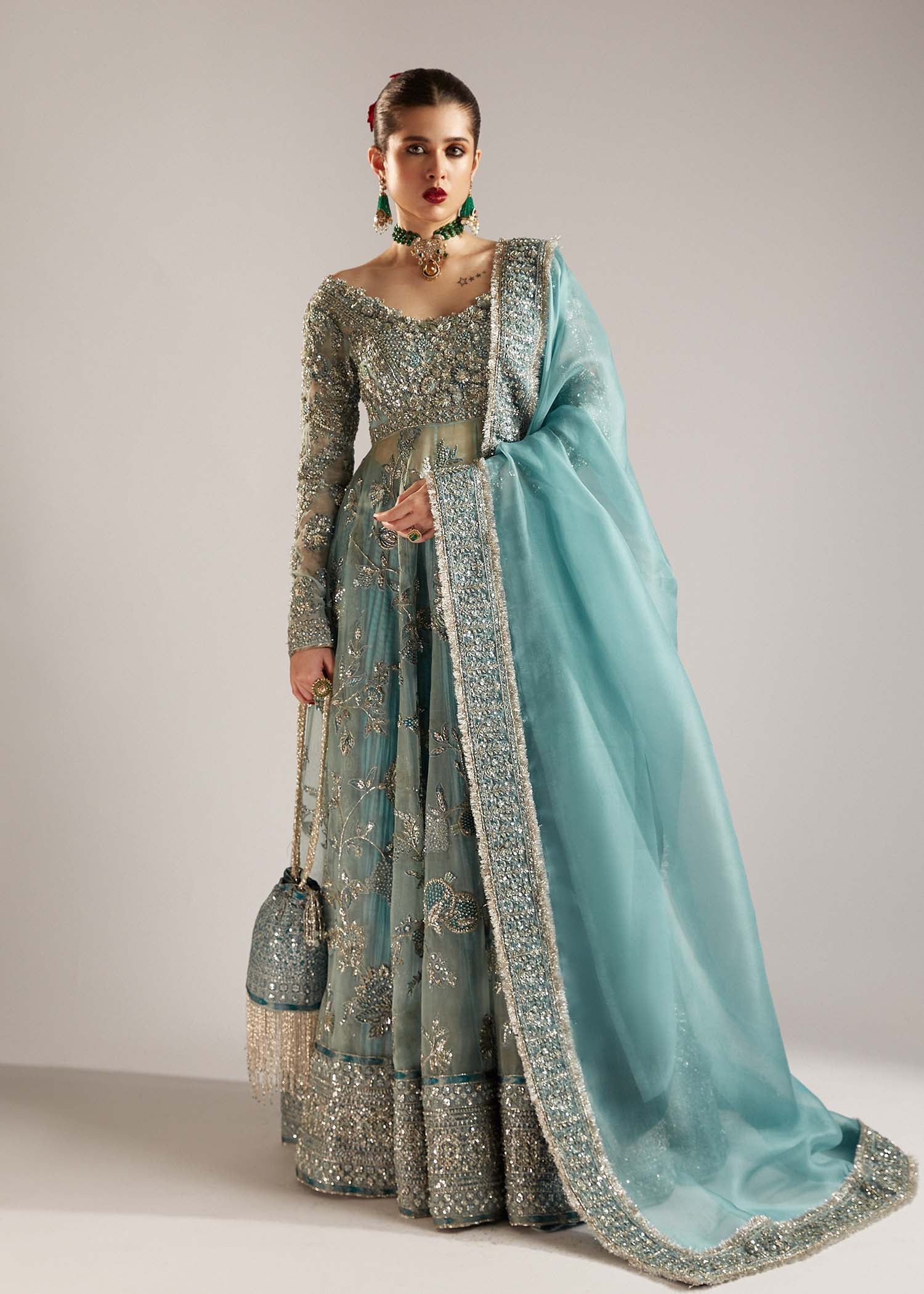  Hussain Rehar Astra ice-blue organza peshwas featuring intricate embellishments on the front and back bodice with heavy embellished borders, paired with a resplendent silk crushed sharara and a digital printed organza dupatta with celestial motifs and four-sided embellished border, perfect for weddings and formal celebrations.
