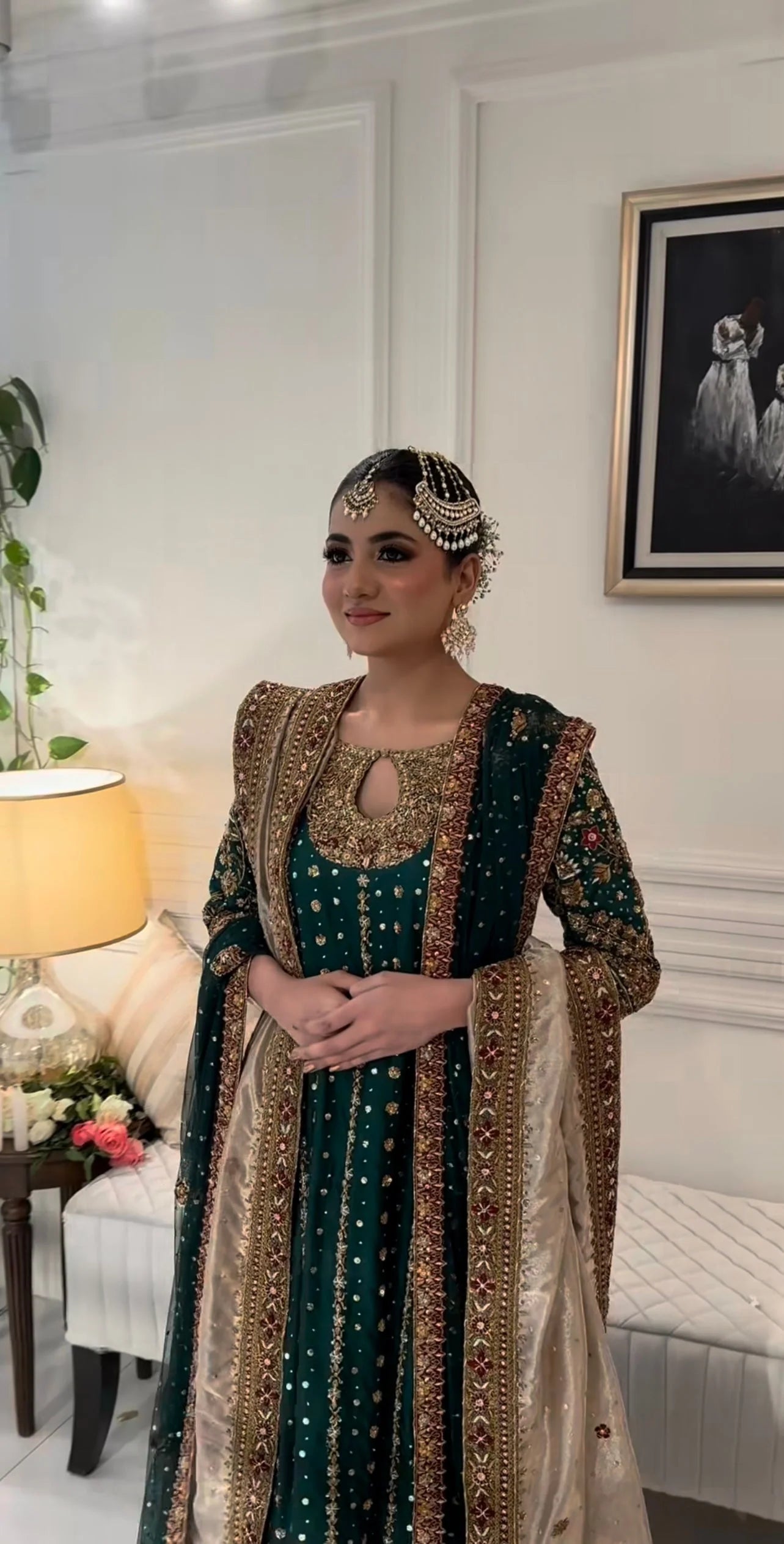 Mehru deep emerald ensemble featuring antique gold and subtle maroon accents with a matching green dupatta edged in ornate red and maroon borders, creating a regal look steeped in timeless tradition and quiet grandeur.