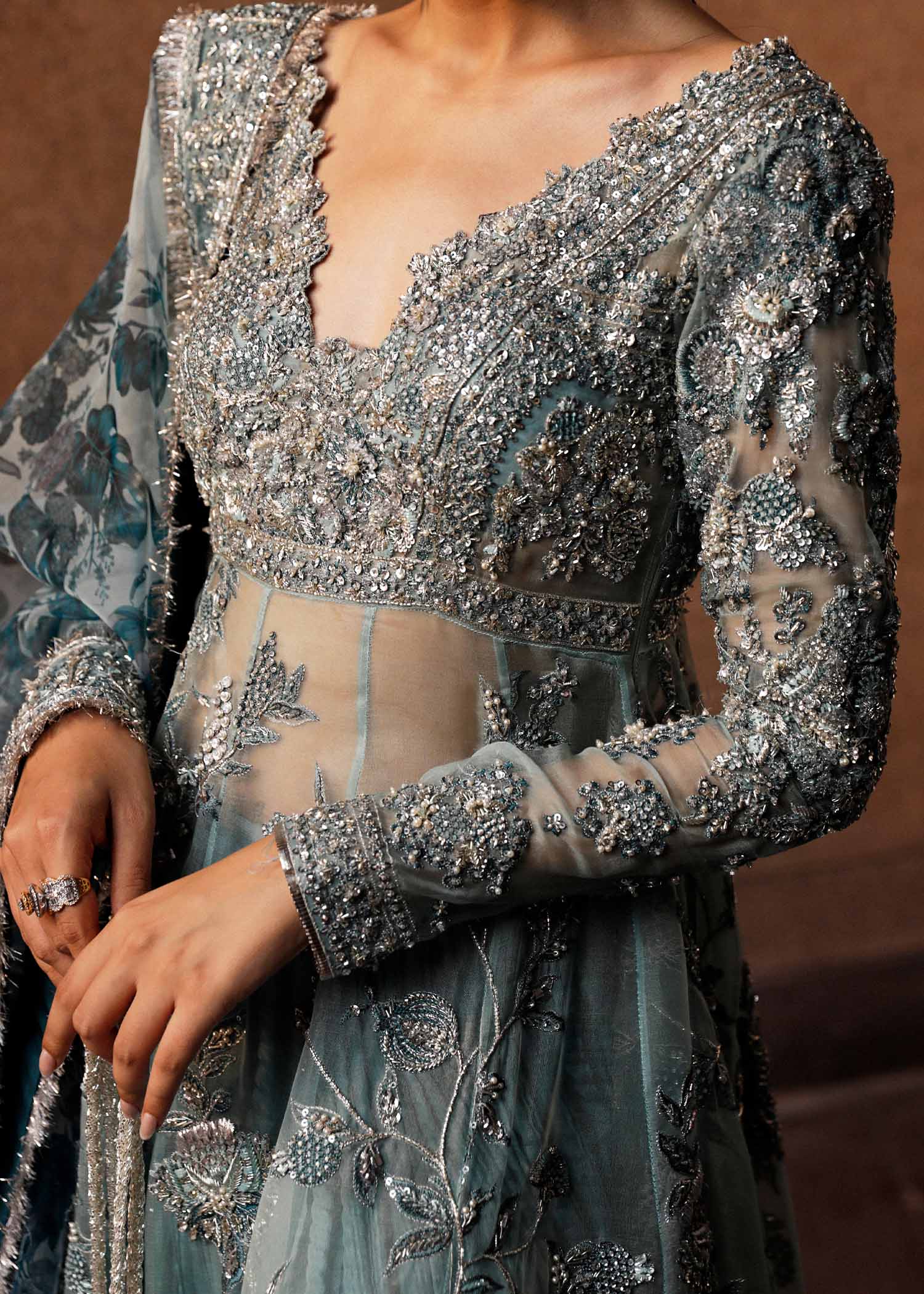  Hussain Rehar Astra ice-blue organza peshwas featuring intricate embellishments on the front and back bodice with heavy embellished borders, paired with a resplendent silk crushed sharara and a digital printed organza dupatta with celestial motifs and four-sided embellished border, perfect for weddings and formal celebrations.

