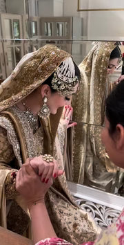 Haris Shakeel Mahrani ivory-gold bridal ensemble featuring a long heavily embellished shirt with intricate handwork including zardozi, dabka, naqshi, and delicate sequin detailing forming graceful floral and traditional motifs, paired with a magnificently worked dupatta with dense borders and finely finished edges, perfect for bridal wear with statement jewelry and traditional headpiece.