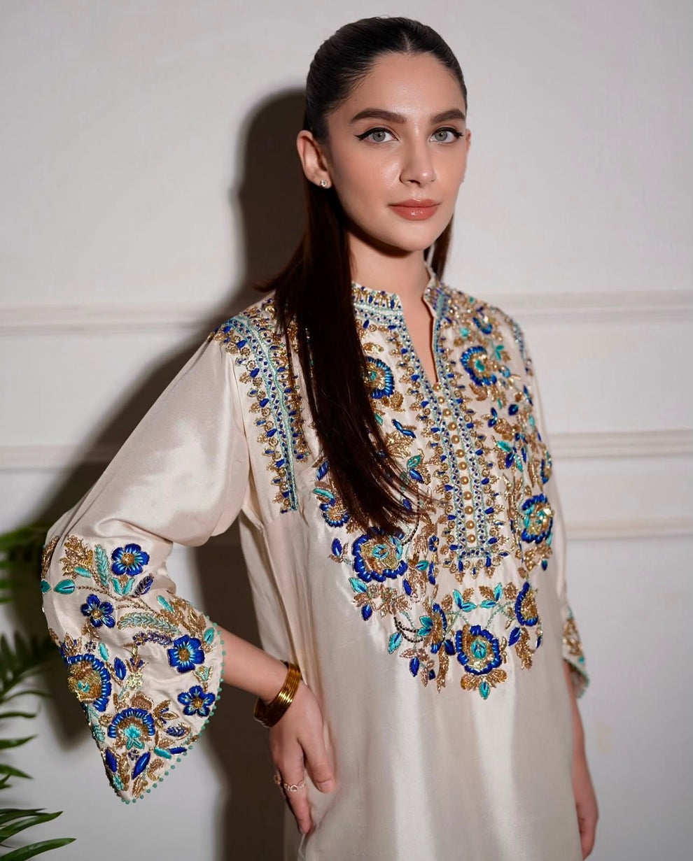 Aleena Khan Aleenah white ensemble featuring a delicately embroidered shirt with intricate motifs, paired with beautifully tailored trousers and a gracefully flowing dupatta, perfect for formal occasions and festive celebrations.