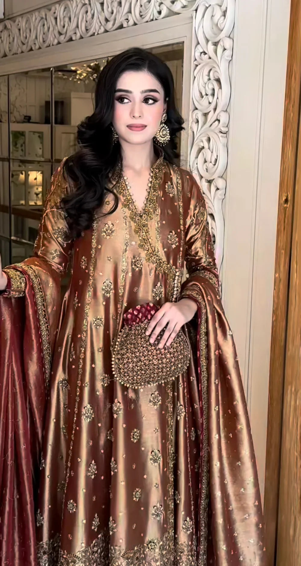 Haris Shakeel Aswad bronze-gold formal ensemble featuring intricate hand embellishments with detailed floral motifs, delicate sequins, and refined accents on an elongated silhouette with a heavily worked hemline, perfect for weddings, receptions, formal dinners, and festive celebrations.
