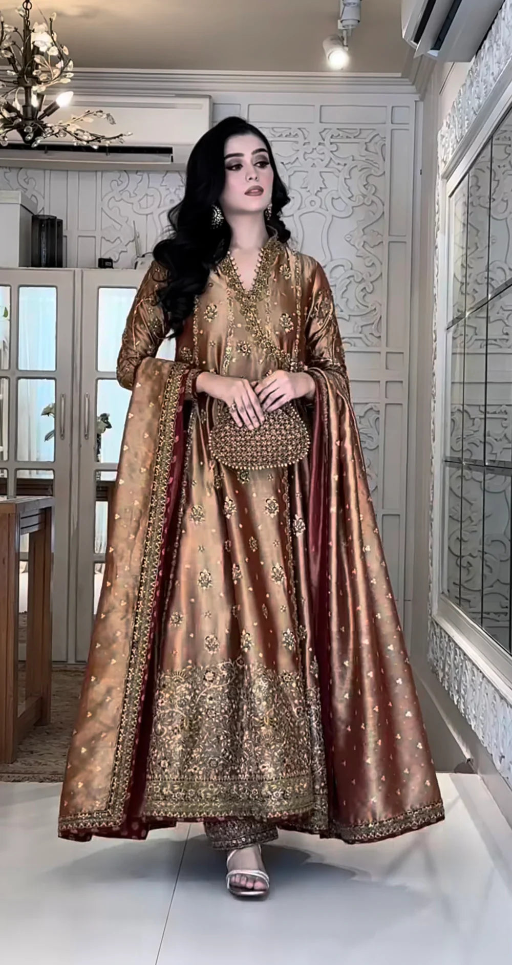 Haris Shakeel Aswad bronze-gold formal ensemble featuring intricate hand embellishments with detailed floral motifs, delicate sequins, and refined accents on an elongated silhouette with a heavily worked hemline, perfect for weddings, receptions, formal dinners, and festive celebrations.