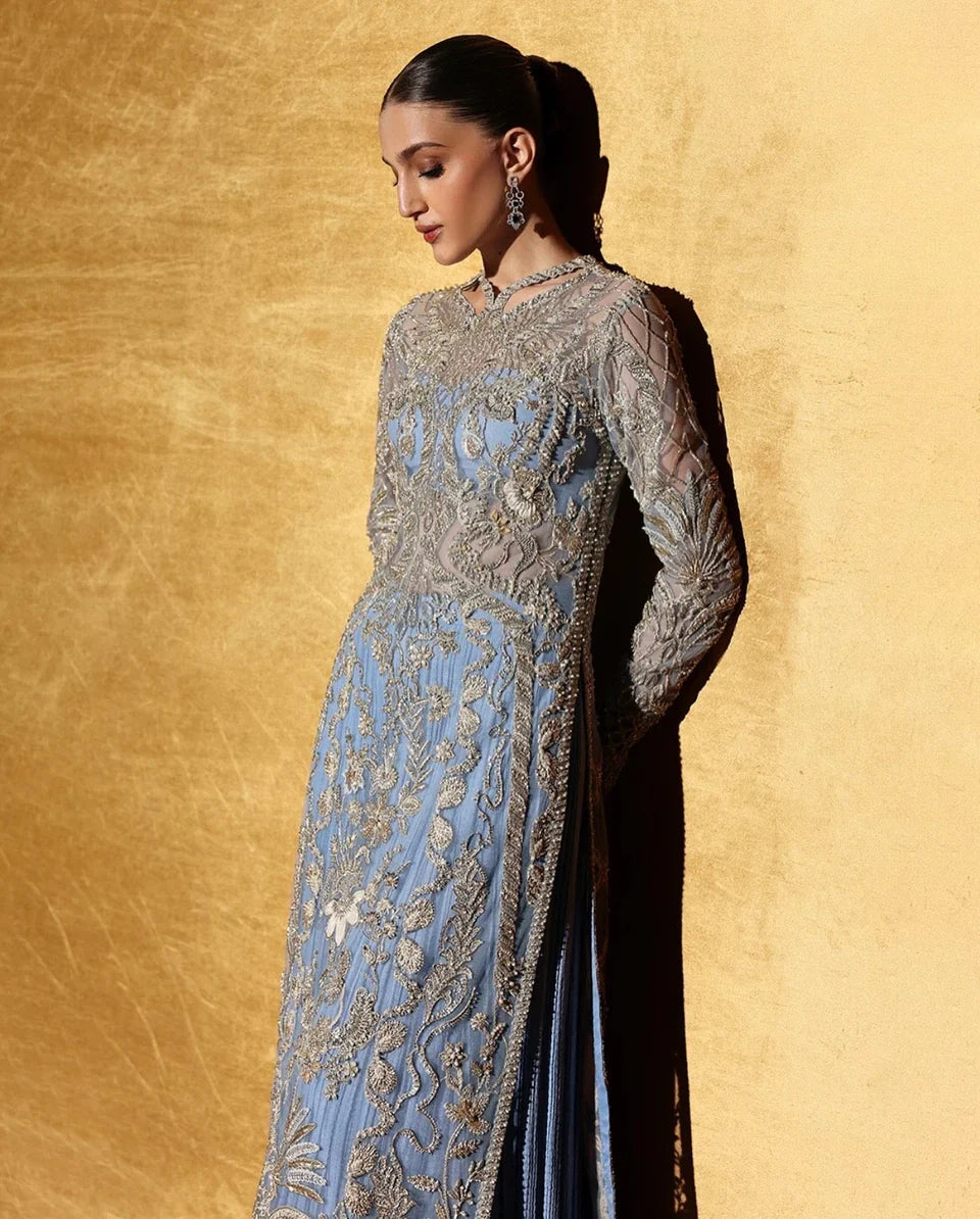 Soraya inspired Seralyn luxury formal ensemble in a soft ethereal pastel palette with subtle warm undertones featuring intricate hand embellishments and shimmering accents on a flowing silhouette with a richly worked bodice and embellished flare, paired with a coordinated dupatta with elegant borders, perfect for weddings and formal celebrations.