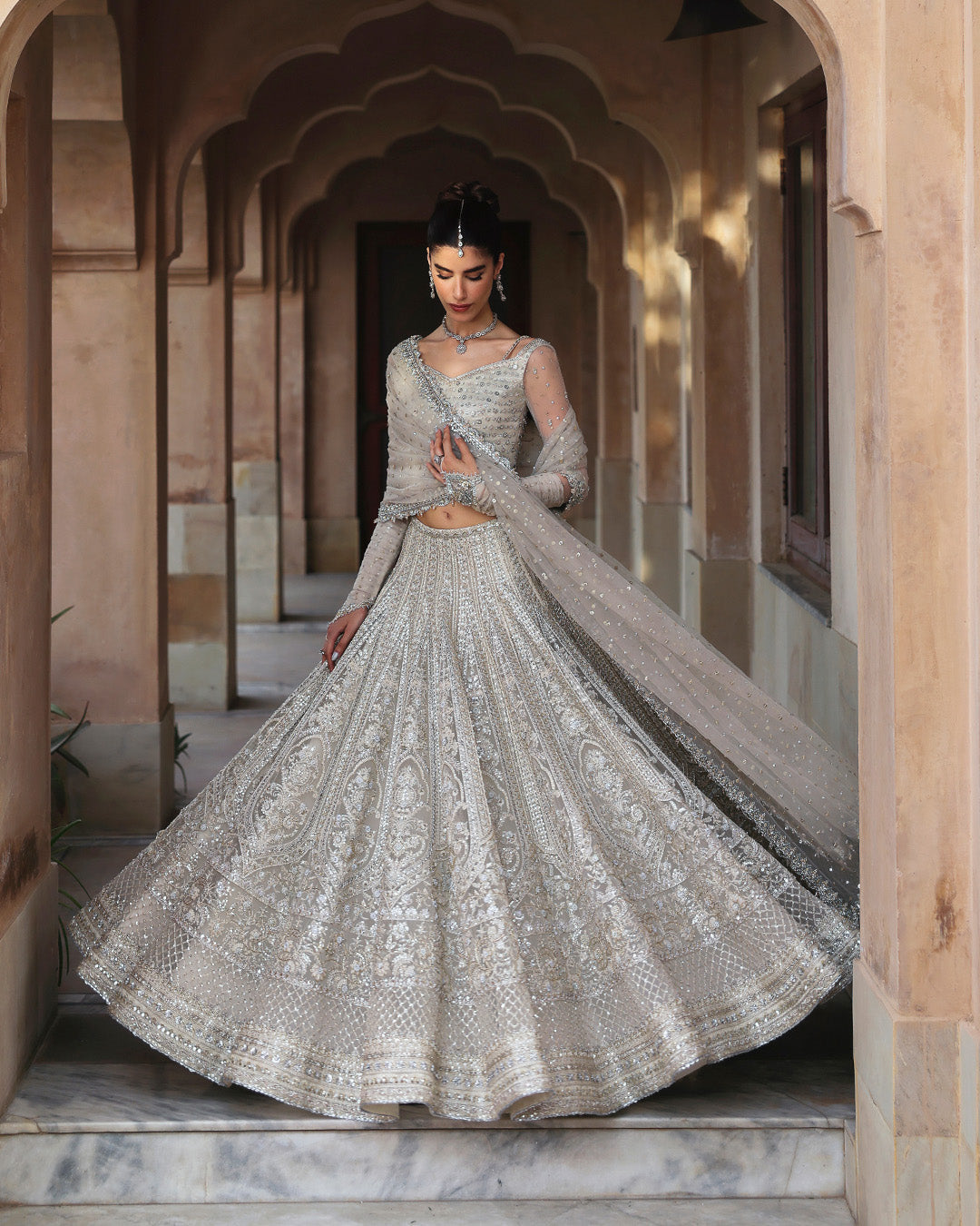 Faiza Saqlain Cammi soft ivory ensemble featuring intricately handworked detailing and delicate embellishments on a flowing silhouette, paired with a sheer dupatta, perfect for weddings and formal occasions.
