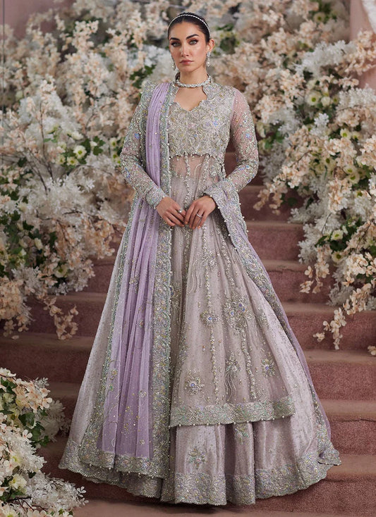 Farah Talib Aziz Elanur lilac bridal kalidaar crafted on pure net with intricate hand embellishments featuring a flared silhouette, paired with a classic lehenga and coordinated net dupatta with subtle embroidery, perfect for wedding festivities and formal celebrations.