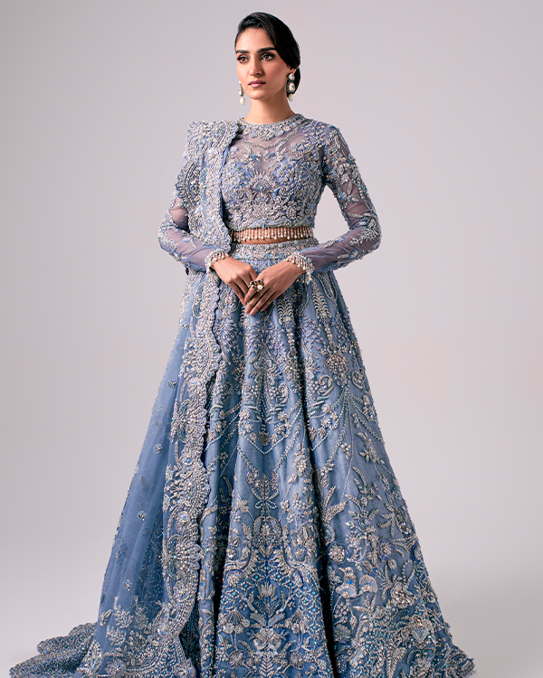 The Nyra Couture Aarzu sky blue net lehenga choli featuring heavy florid embroidery with resham thread, naqshi, dabka, sequin, and pearls, paired with a heavy net dupatta, perfect for wedding celebrations and bridal events.