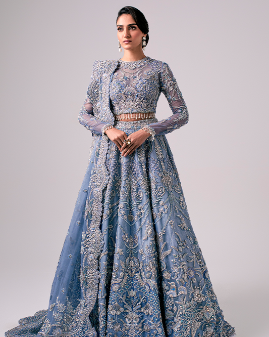 The Nyra Couture Aarzu sky blue net lehenga choli featuring heavy florid embroidery with resham thread, naqshi, dabka, sequin, and pearls, paired with a heavy net dupatta, perfect for wedding celebrations and bridal events.