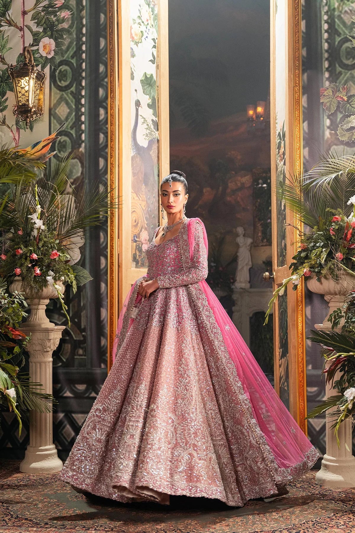  Fahad Hussayn Bagaai pink net bridal lehenga choli featuring intricate resham embroidery, fine sequin detailing, elaborate zardozi work, and hand-placed crystals on a delicate net fabric base, with a flowing embroidered lehenga, coordinated choli, and matching dupatta, perfect for wedding ceremonies, receptions, and grand bridal events.