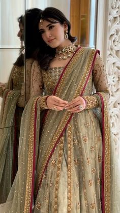 Haris Shakeel pistachio green lehenga choli featuring intricate gold embroidery, delicate hand embellishments, fine zari, sequins, and detailed floral motifs on a soft pastel base, paired with a full-sleeved embellished choli and a sheer net dupatta with rich gold detailing and a contrasting deep pink border, perfect for nikah, engagement, walima, and formal wedding events.