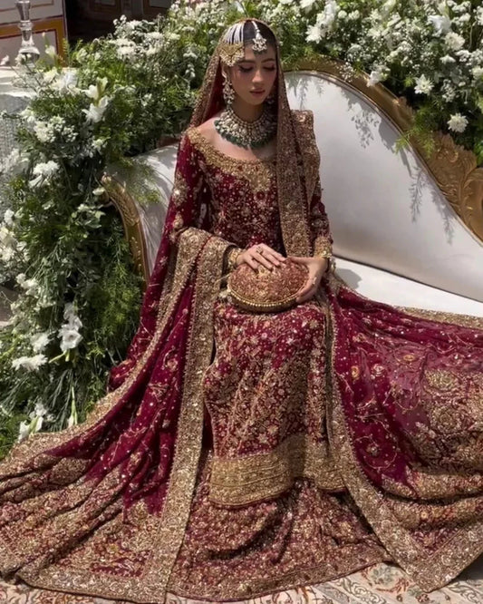 Haris Shakeel Ishq Series bridal ensemble in deep romantic maroon featuring intricate adda work and hand embellishment with fine dabka and handworked motifs spread generously across the shirt, sleeves, and flowing lehenga with richly embellished borders, paired with a heavily worked dupatta with ornate edging, perfect for brides seeking classic sophistication and traditional grandeur.