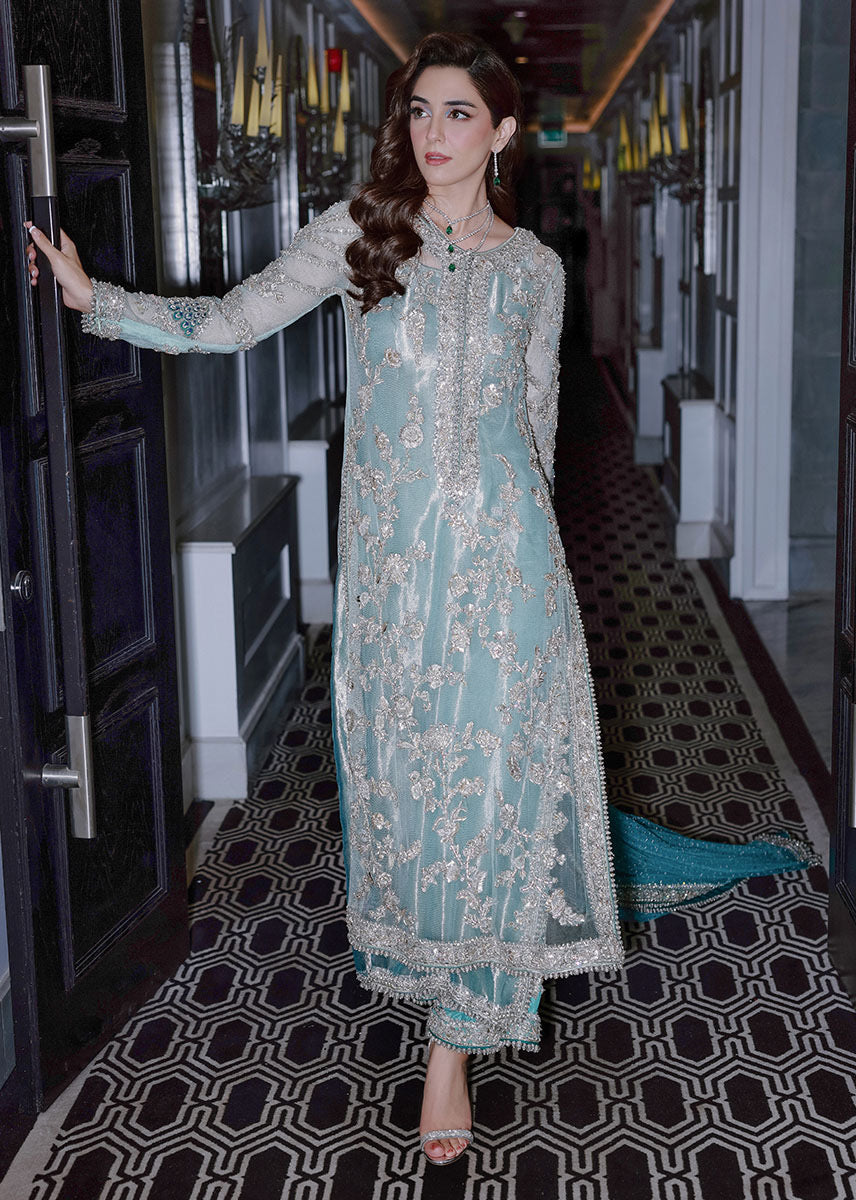 Sara Rohale Asghar Ferozeah aqua long shirt featuring intricate silver embellishments with hand-embroidered floral motifs creating a refined jal, paired with a sheer dupatta with heavily embellished border and scattered sequins, and straight-cut azar trousers with bejeweled peacock hem in silver threadwork, perfect for formal occasions and statement looks.