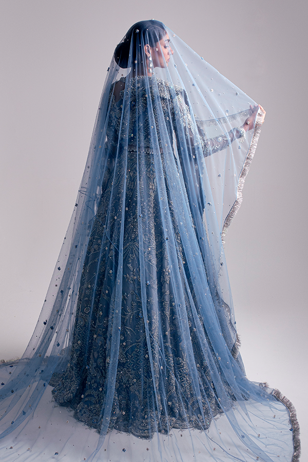 The Nyra Couture Aarzu sky blue net lehenga choli featuring heavy florid embroidery with resham thread, naqshi, dabka, sequin, and pearls, paired with a heavy net dupatta, perfect for wedding celebrations and bridal events.