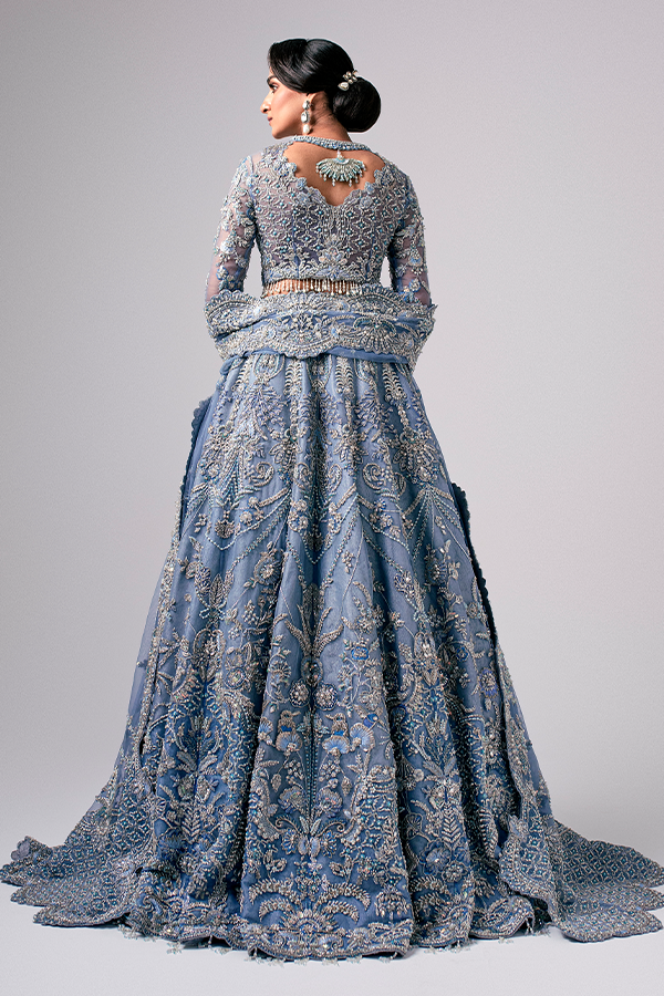The Nyra Couture Aarzu sky blue net lehenga choli featuring heavy florid embroidery with resham thread, naqshi, dabka, sequin, and pearls, paired with a heavy net dupatta, perfect for wedding celebrations and bridal events.