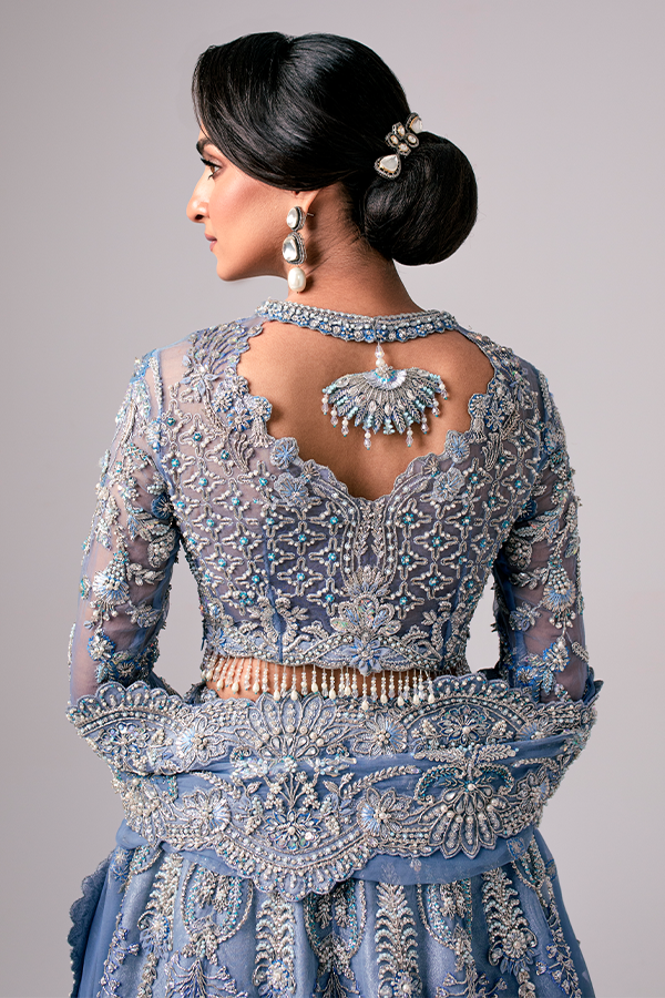 The Nyra Couture Aarzu sky blue net lehenga choli featuring heavy florid embroidery with resham thread, naqshi, dabka, sequin, and pearls, paired with a heavy net dupatta, perfect for wedding celebrations and bridal events.