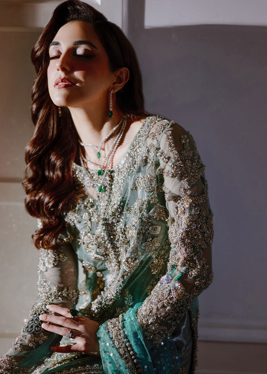 Sara Rohale Asghar Ferozeah aqua long shirt featuring intricate silver embellishments with hand-embroidered floral motifs creating a refined jal, paired with a sheer dupatta with heavily embellished border and scattered sequins, and straight-cut azar trousers with bejeweled peacock hem in silver threadwork, perfect for formal occasions and statement looks.